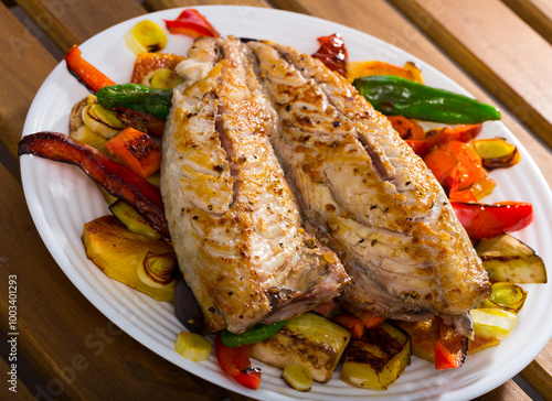 Dish of Bulgarian cuisine - grilled vegetables with fried scomber served on plate photo