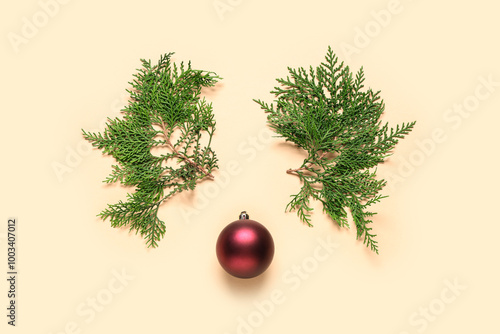 Reindeer face made of coniferous branches with Christmas ball on beige background photo