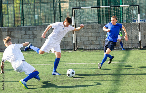 Football player swings his leg for kick in direction of goal photo