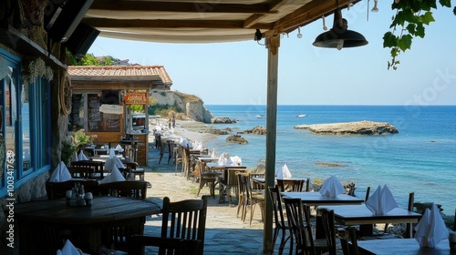 A beachside cafa with tables overlooking the sea, with the ocean breeze ruffling the napkins. photo