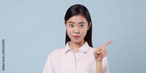 Young Woman Pointing to the Side on Blue Background
