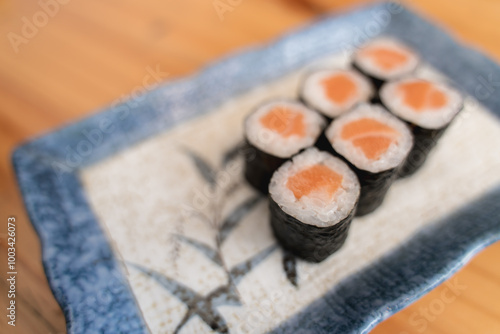 Six pieces of salmon maki sushi on a decorative plate. photo