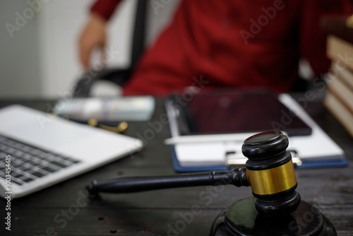 close-up of a lawyer’s hands working at a desk, reviewing legal documents and contracts, with a wooden gavel nearby, symbolizing law, legislation, and the potential complexities of bribery cases.