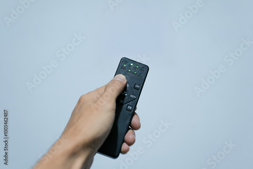 Wallpaper Mural a hand is holding a remote Torontodigital.ca