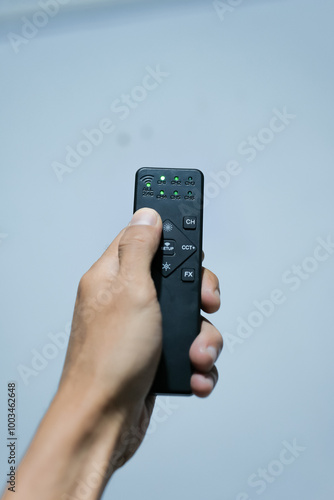 Wallpaper Mural a hand is holding a remote Torontodigital.ca