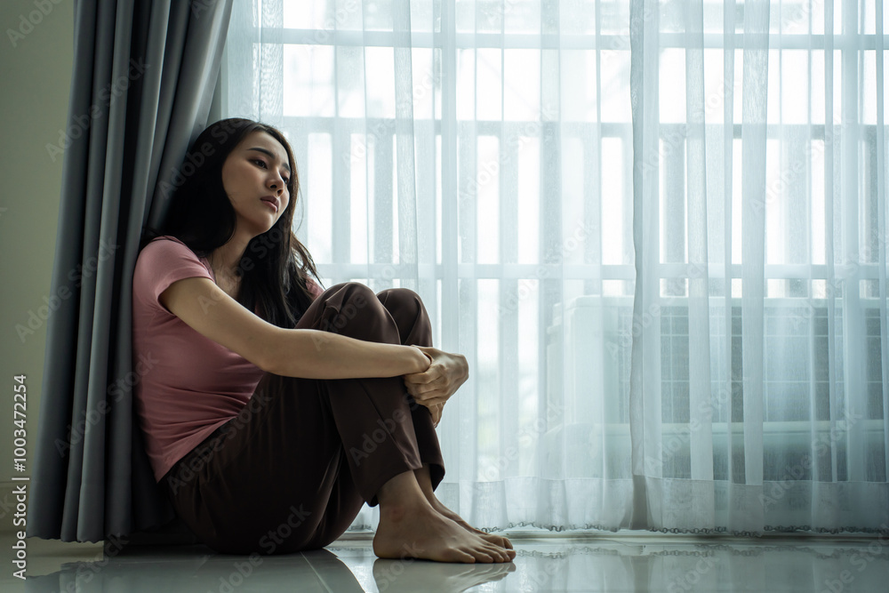 Asian young upset depressed woman sitting alone in living room at home. Asian young upset depressed woman sitting alone in living room at home.