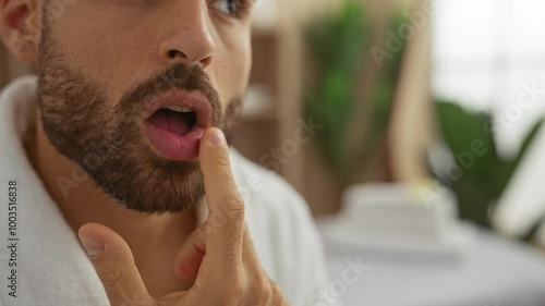 Young man with a beard touching his face in a spa's relaxing interior, highlighting the wellness atmosphere of the beauty center photo