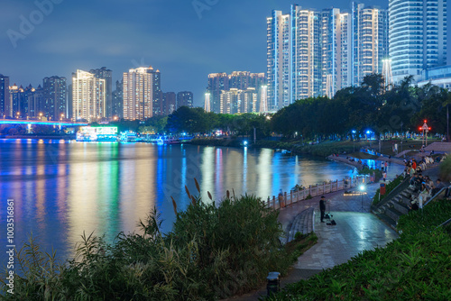 Night lighting of high-rise buildings in riverside cities #1003516861