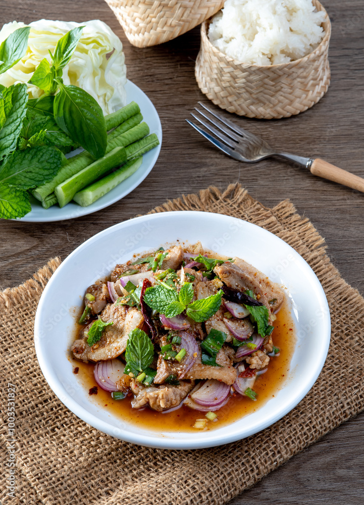 Grilled pork salad on the wooden table. Thai food. Isaan food. Grilled pork salad on the wooden table. Thai food. Isaan food.