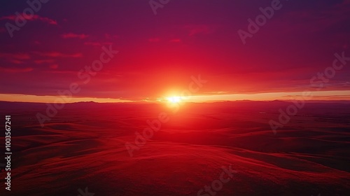 A fiery red sky sets the scene for a dramatic sunset over rolling hills.