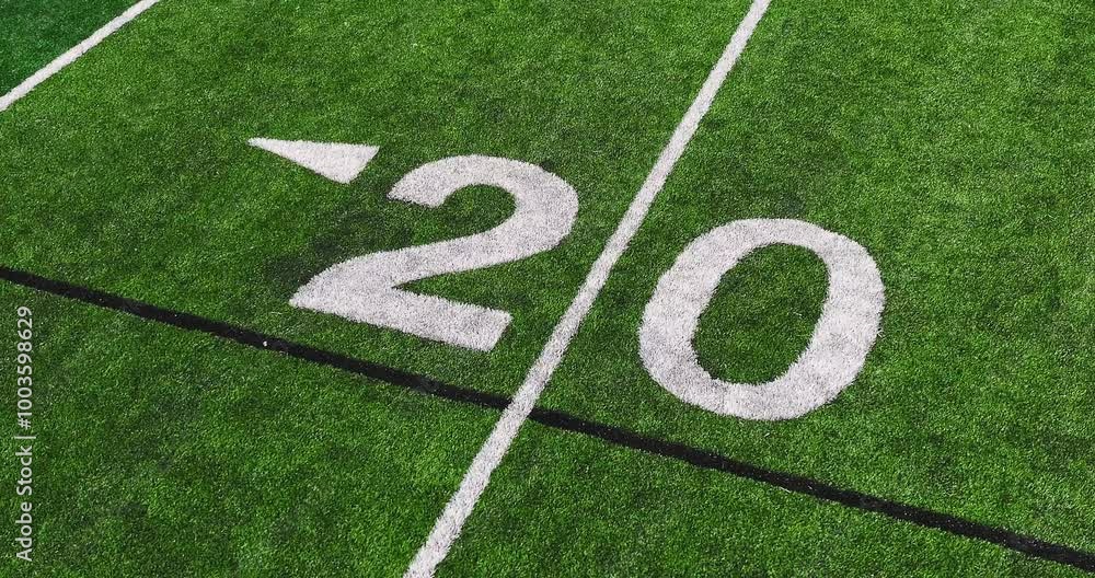 Aerial video of a typical synthetic turf football field 20 yard line in white. Aerial video of a typical synthetic turf football field 20 yard line in white.