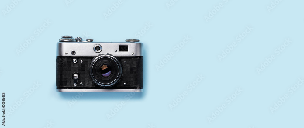 Fototapeta premium A vintage retro camera placed flat on a bright blue background