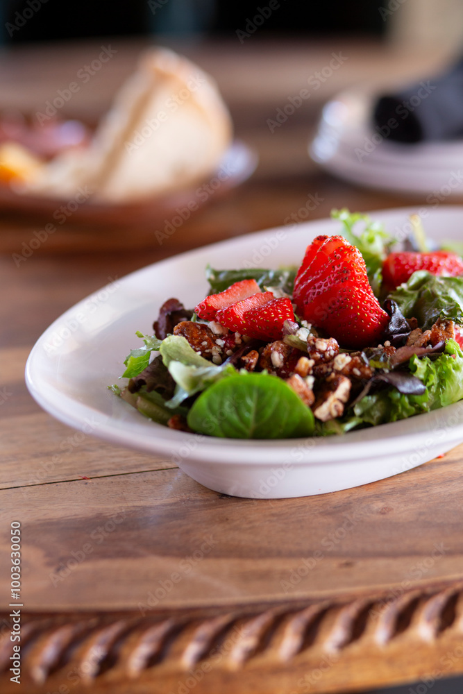 Strawberry salad with candied nuts and mixed greens vertical Strawberry salad with candied nuts and mixed greens vertical