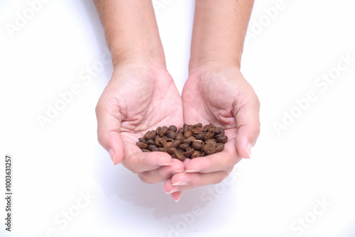 two hands showing a handful of newly roasted coffee beans photo