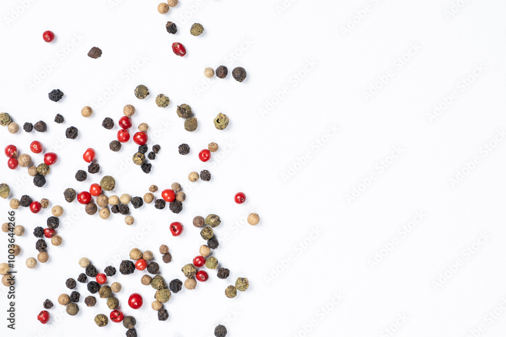 Red, green, white and black peppercorns on a white background, copy space for text Red, green, white and black peppercorns on a white background, copy space for text