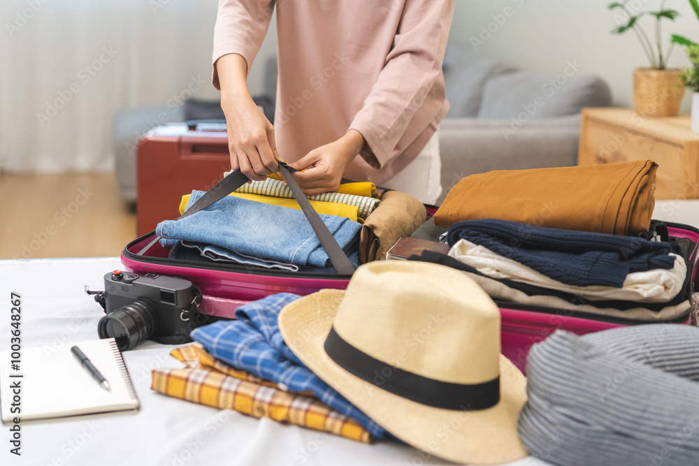© KMPZZZ - Vacation, holiday travel, traveler asian young woman, girl strap belt, packing, buckle preparing stuff into luggage or baggage bag case for journey trip, preparation for journey voyage at home © KMPZZZ - Vacation, holiday travel, traveler asian young woman, girl strap belt, packing, buckle preparing stuff into luggage or baggage bag case for journey trip, preparation for journey voyage at home