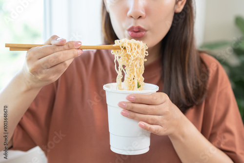 Bild auf Leinwand Happy temptation, attractive asian young student woman, cute girl using chopsticks eating instant ramen, noodles soup from a cup, cooking meal fast food lifestyle of traditional japanese person