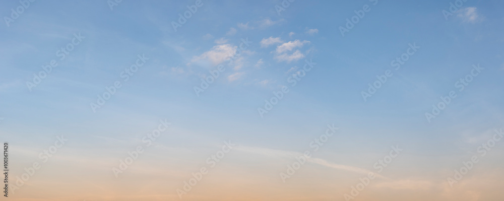 Fototapeta premium The clear gradient sky with white clouds provides a bright and sunny background, enhancing the natural beauty of the landscape on this pleasant summer sunset day