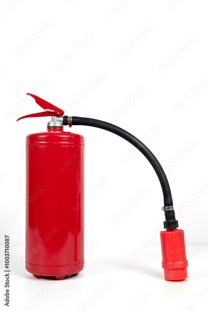 Fototapeta premium A red fire extinguisher with black hose on white background