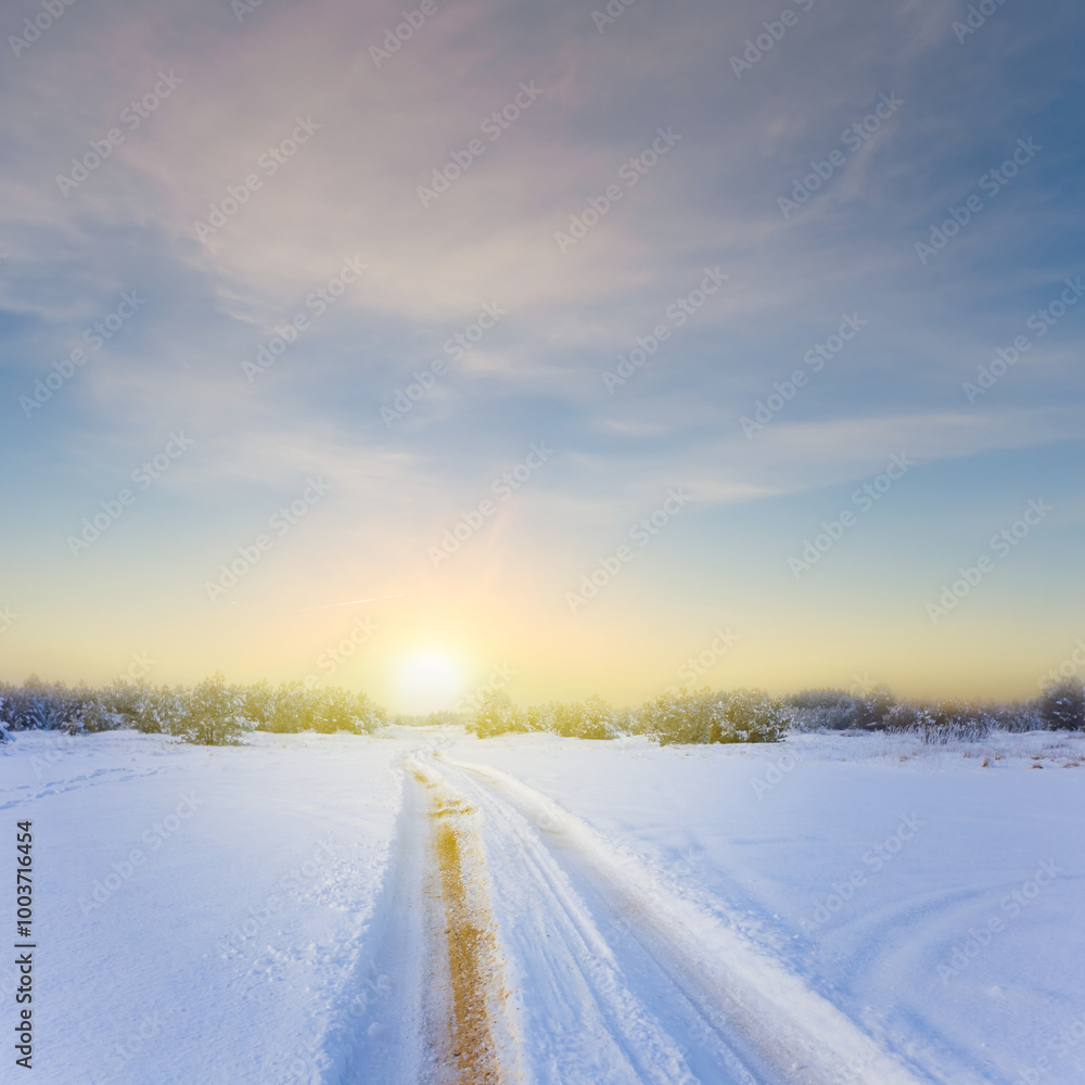 wide snowbound winter plain with road at the sunset wide snowbound winter plain with road at the sunset