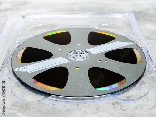 Recordable laser disc with a label stylized as an analog tape or film on a reel with an empty area for the title in a case photo