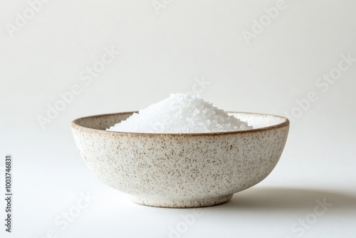 A simple bowl filled with coarse kosher salt on a clean surface for culinary use photo