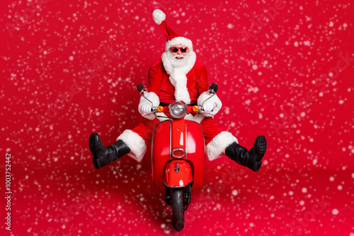 Full length photo of retired grandfather white beard crazy careless ride retro moped wind blow face high speed wear x-mas costume coat sunglass cap boots isolated red color background photo