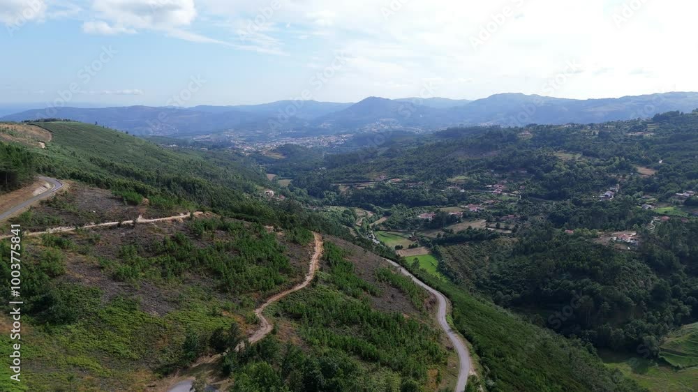 Aerial - winding roads through green mountains in the interior of Portugal, with expansive valleys below Aerial - winding roads through green mountains in the interior of Portugal, with expansive valleys below