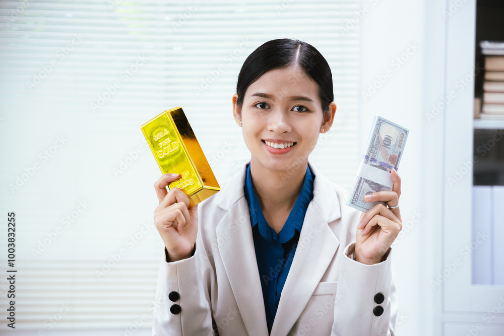 Excited beautiful businesswoman holding gold bars and silver bars in her hands and making a happy gesture in the office. Excited beautiful businesswoman holding gold bars and silver bars in her hands and making a happy gesture in the office.