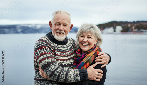 Portrait of happy scandinavian senior couple embracing each other in front of the nordic winter sea
