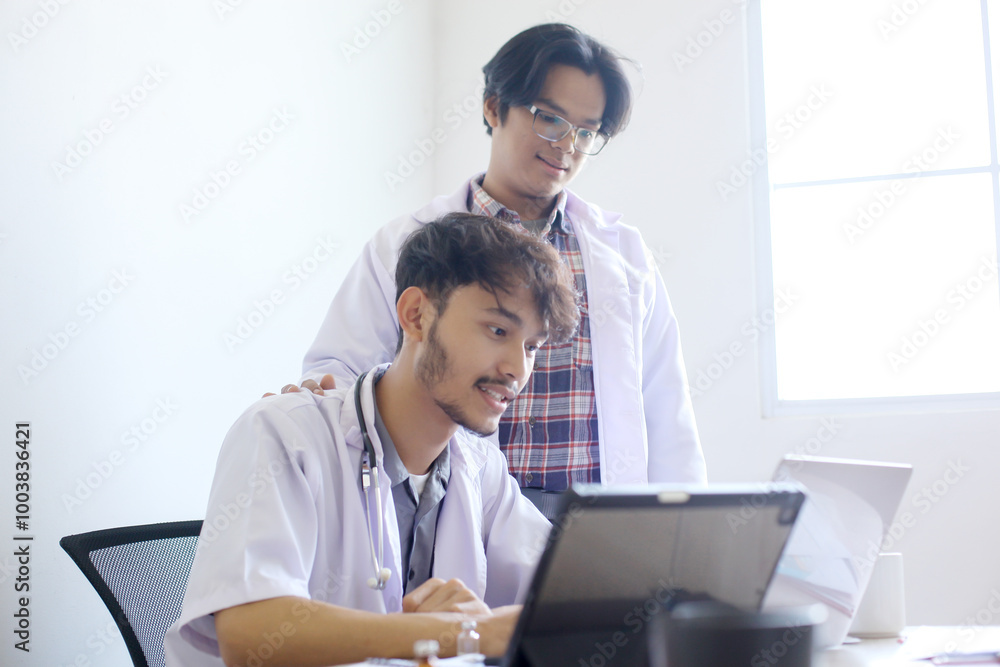 Young Asian Medical Students In Uniform Are Discussing And Researching Medical Information On A Laptop Young Asian Medical Students In Uniform Are Discussing And Researching Medical Information On A Laptop