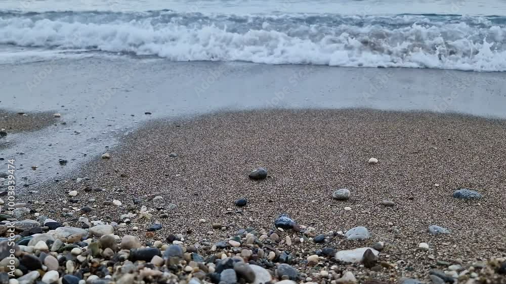 Waves in the sea. A pebble beach. The shore of the sea beach with waves in the ocean. Waves in the sea. A pebble beach. The shore of the sea beach with waves in the ocean.