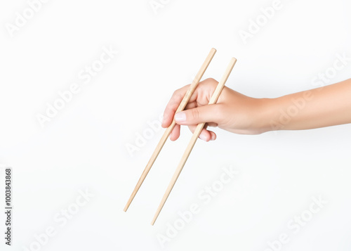 hand holding wooden chopsticks on white background