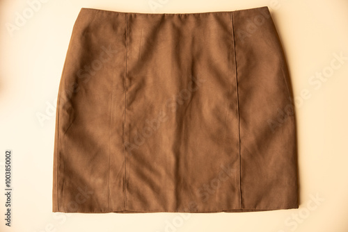 Photos Light brown artificial suede mini skirt lies on a peach fuzz background