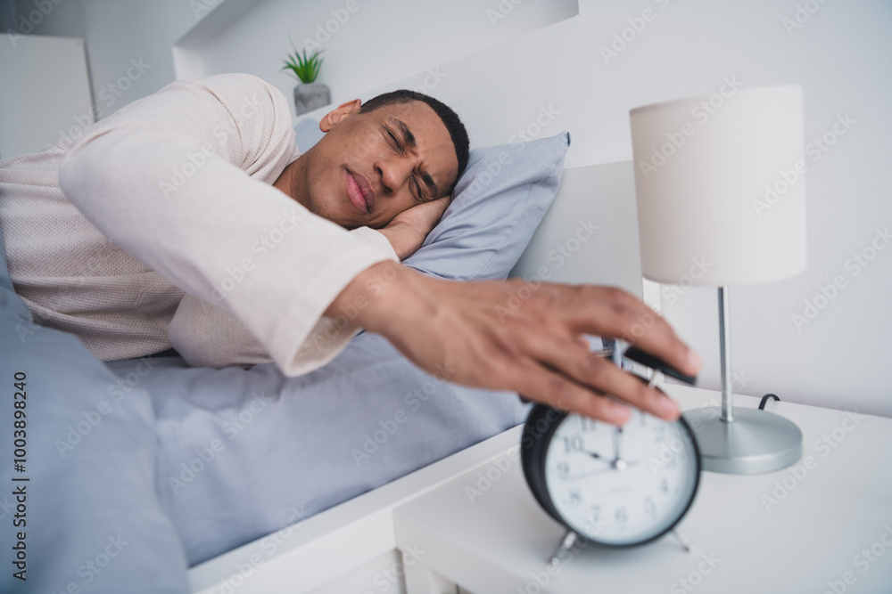 Photo of nice young man lying bed wake up alarm clock wear pajama enjoy wake up modern cozy interior bedroom indoors Photo of nice young man lying bed wake up alarm clock wear pajama enjoy wake up modern cozy interior bedroom indoors