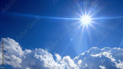 Bright sunshine shining through puffy clouds in a clear blue sky.