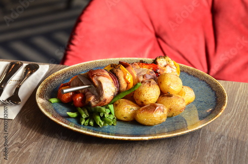 pork skewer with vegetables, served in a restaurant