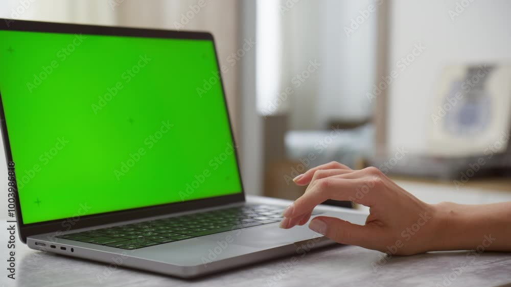 Laptop with Green Screen on Table and Hand Touching Keyboard Laptop with Green Screen on Table and Hand Touching Keyboard