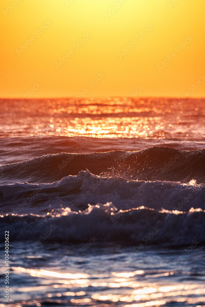 Naklejka premium Beautiful sunrise over the sea splashing waves, vertical landscape