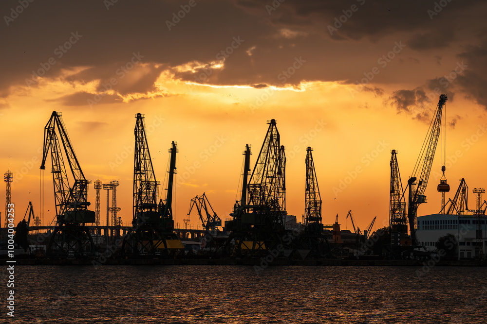Sea port and industrial cranes, Varna, Bulgaria.Sunset over the sea lake and city Sea port and industrial cranes, Varna, Bulgaria.Sunset over the sea lake and city