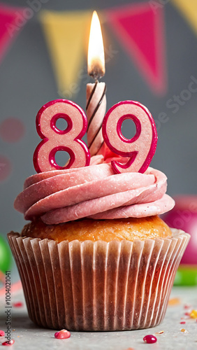 Birthday cupcake with burning lit candle with number 89. Number eighty-nine for eighty-nine years or eighty-ninth anniversary. photo