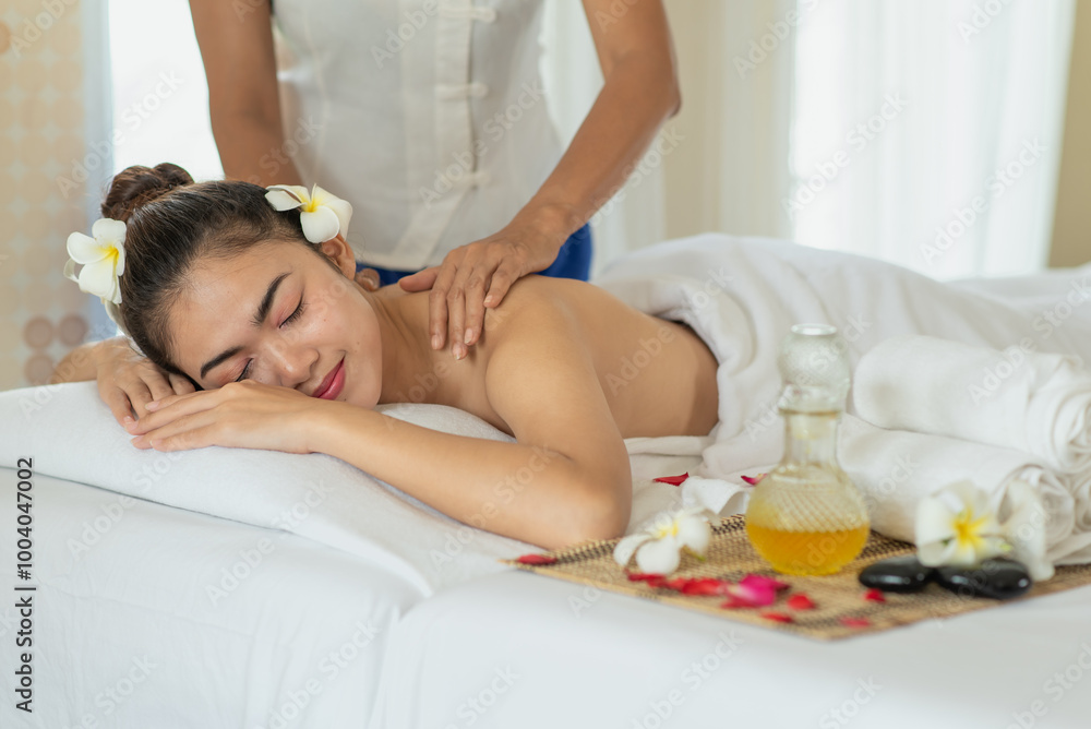 Young Asian woman getting massage in the spa salon, enjoying and relaxing