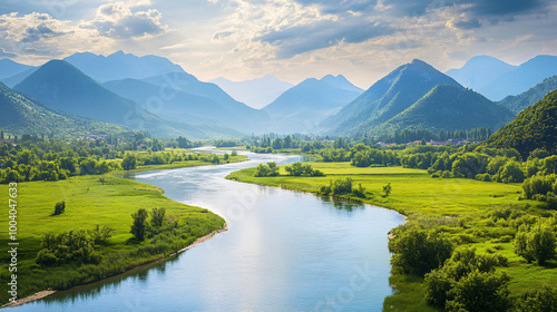  A wide river flowing through a green valley with distant mountains. 