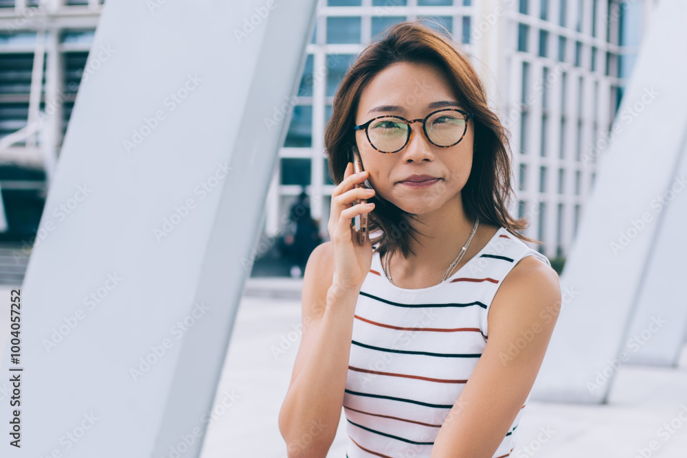 Portrait of attractive female student with takeaway cup sitting outdoors and calling to customer service for checking account bank balance, beautiful Japanese woman making international conversation Portrait of attractive female student with takeaway cup sitting outdoors and calling to customer service for checking account bank balance, beautiful Japanese woman making international conversation