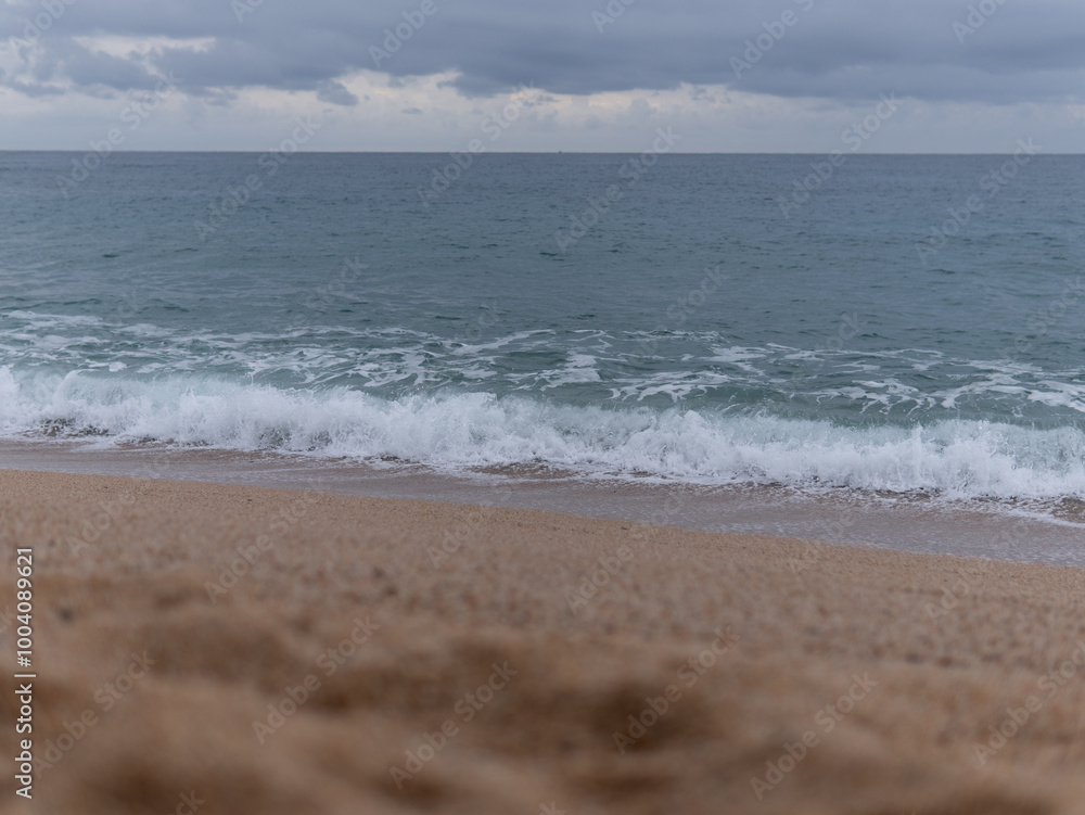 the sea waves at the sandy shore, beating against the rocks. A sailboat at sea. A pigeon sky over a blue sea. the sea waves at the sandy shore, beating against the rocks. A sailboat at sea. A pigeon sky over a blue sea.