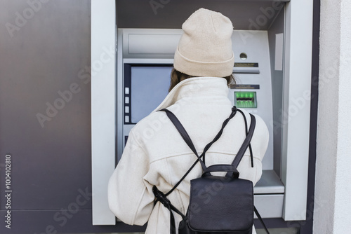 Young woman using ATM. Secure transaction background. Protect your money. Female withdrawing cash with credit card. Banking system background.