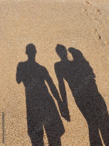 The shadow of people on the sand, mom, dad, child, by the sea