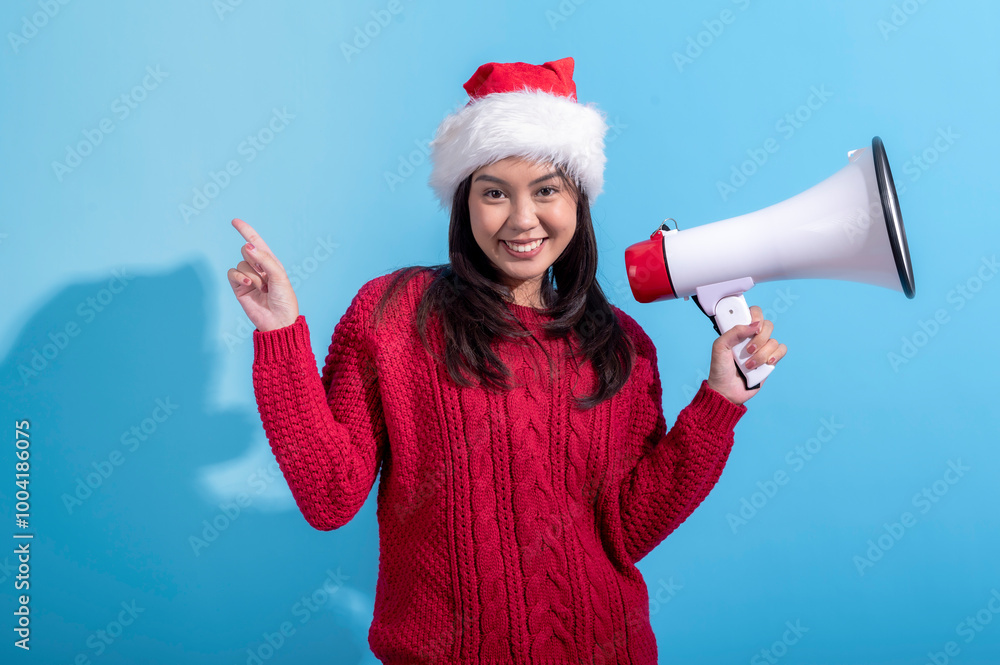 An Asian woman wearing a red knitted sweater and Santa hat holds a megaphone in her left hand while pointing, She has a surprised, set against a light blue background An Asian woman wearing a red knitted sweater and Santa hat holds a megaphone in her left hand while pointing, She has a surprised, set against a light blue background