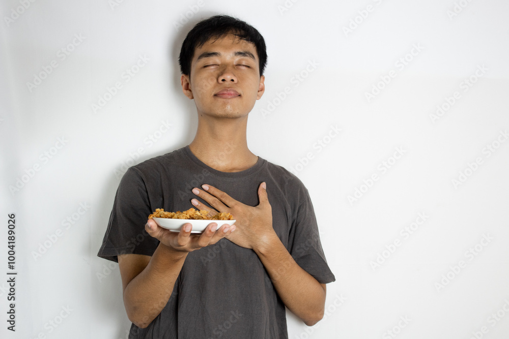 teenager is looking up and holding a plate of crispy shrimp in his hands teenager is looking up and holding a plate of crispy shrimp in his hands