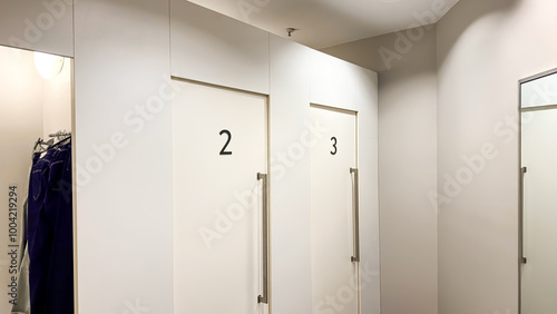 A view of numbered fitting rooms inside a clothing store, with doors labeled 2 and 3.


